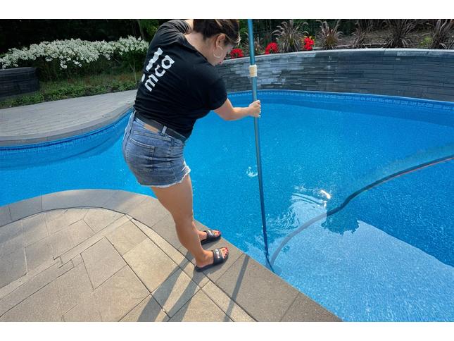 Balayeuse de piscine en action dans un jardin résidentiel


